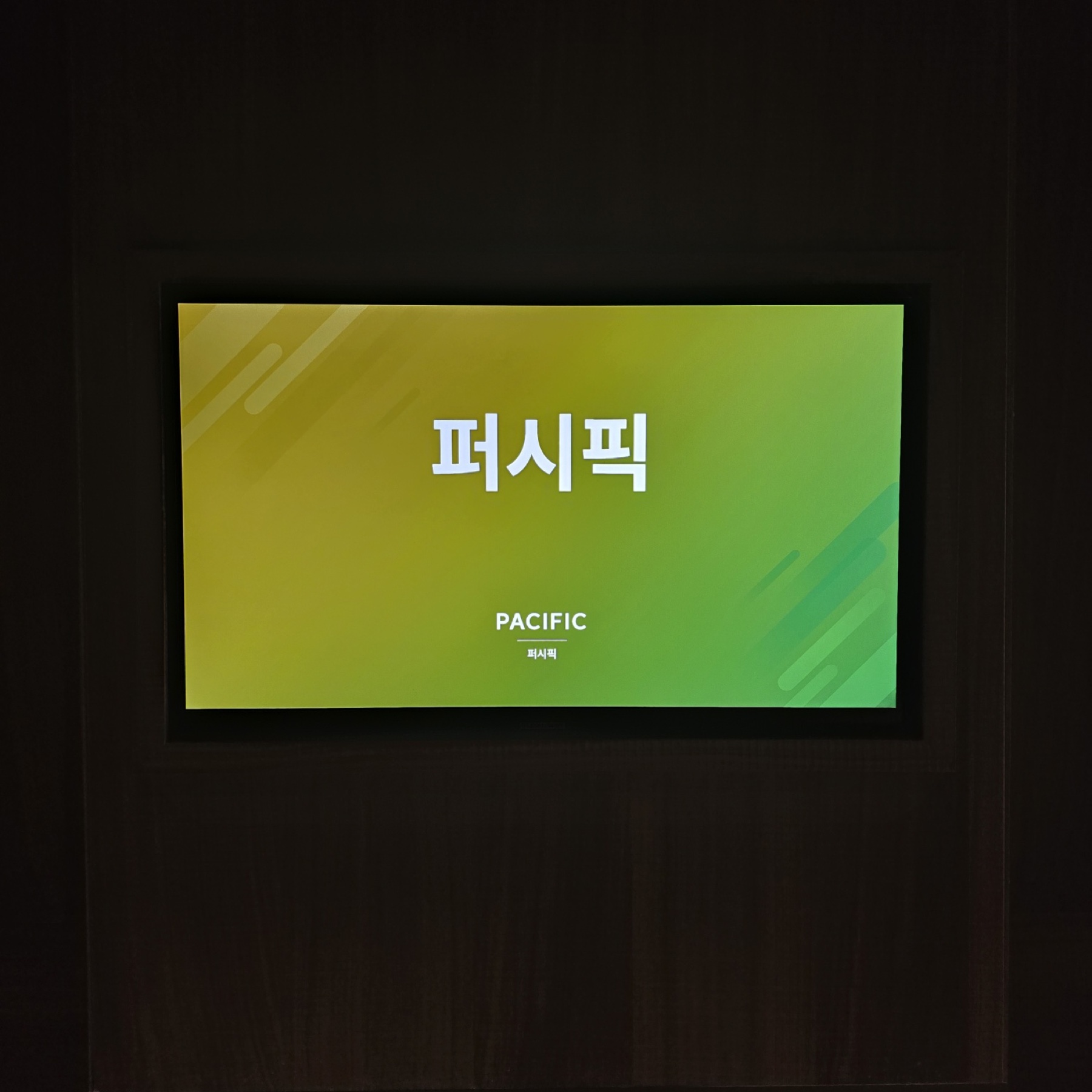 만든 사이니지가 실제로 걸려 있는 모습. 편집기에서 지정한 배경·제목·영문 표기가 그대로 매장 벽면 디스플레이에 표출된다.